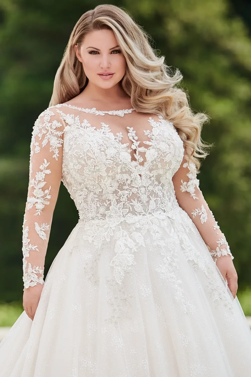 A woman in a beautiful, elegant wedding dress with long sleeves, featuring intricate lace details and a full skirt.