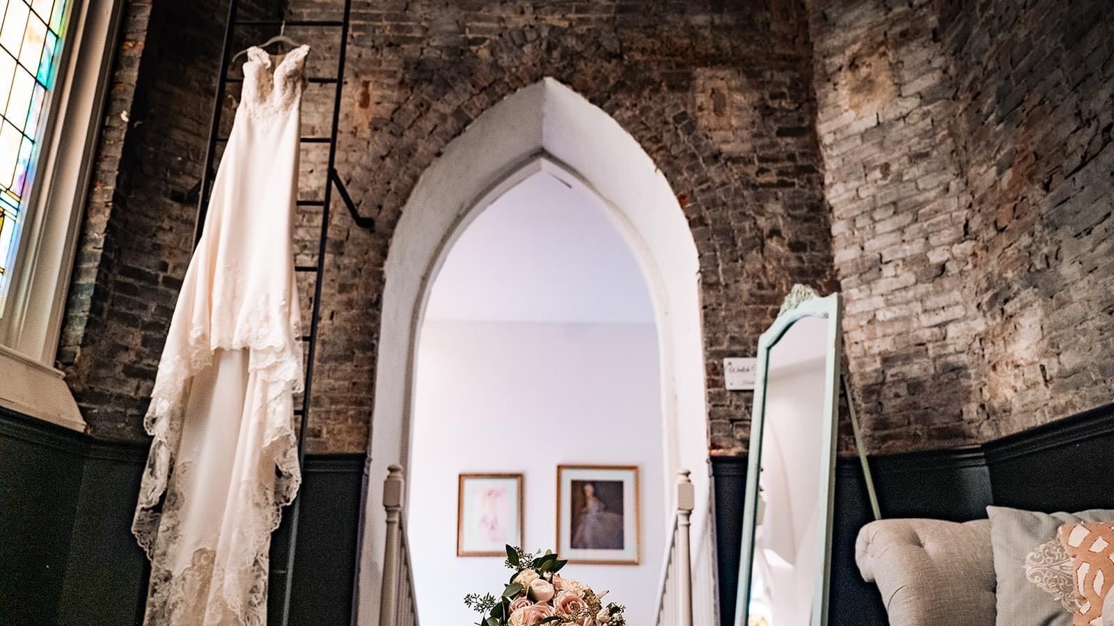wedding dress hanging in vintage church 