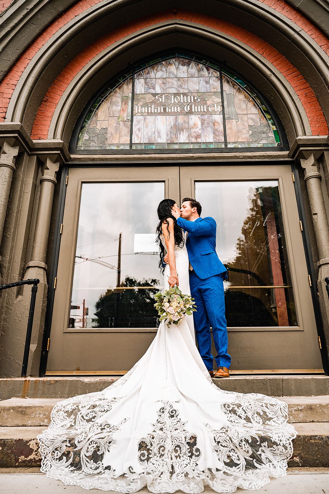 Bride and groom kissing in front of church