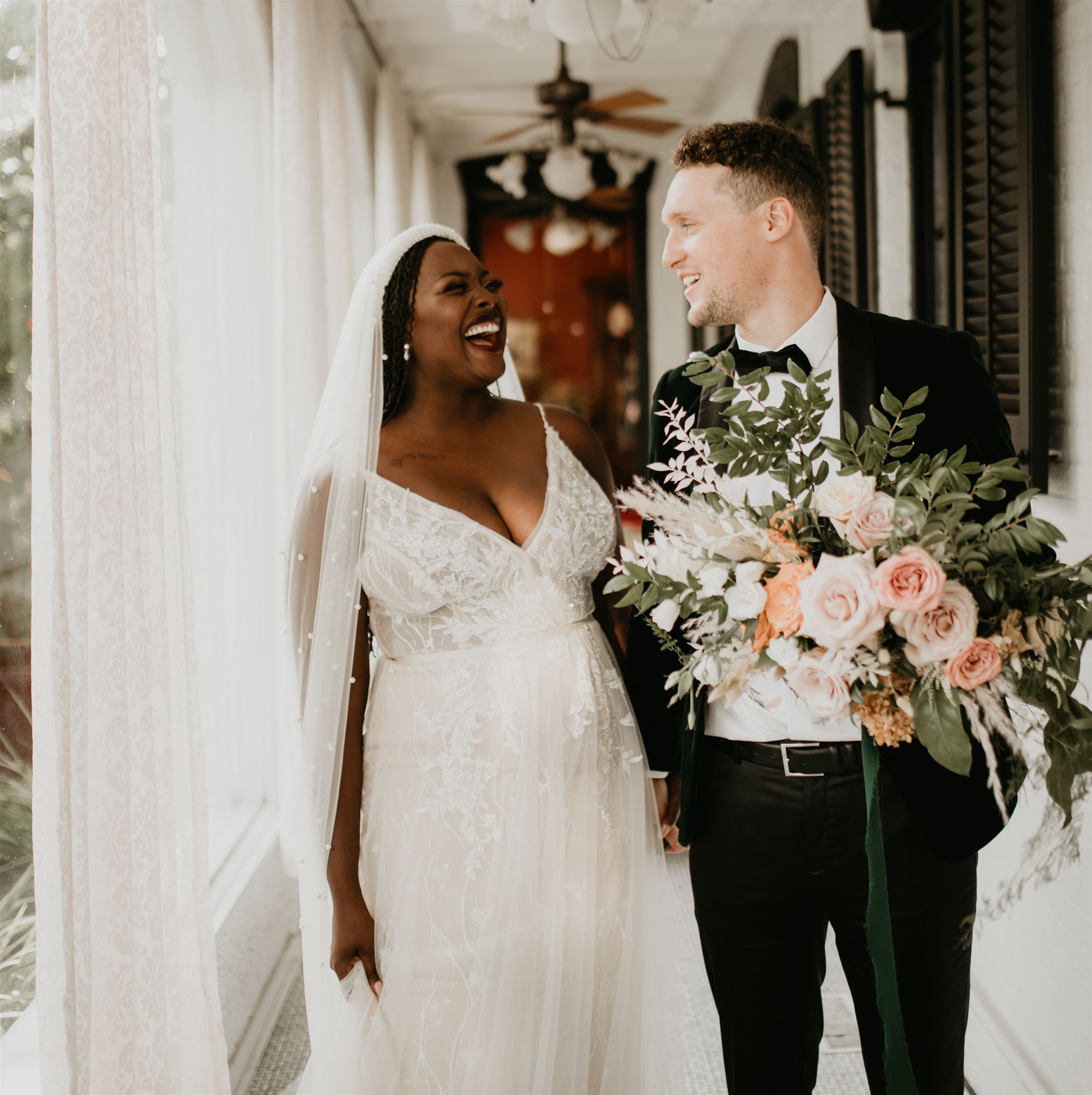 Bride and groom laughing together in wedding venue