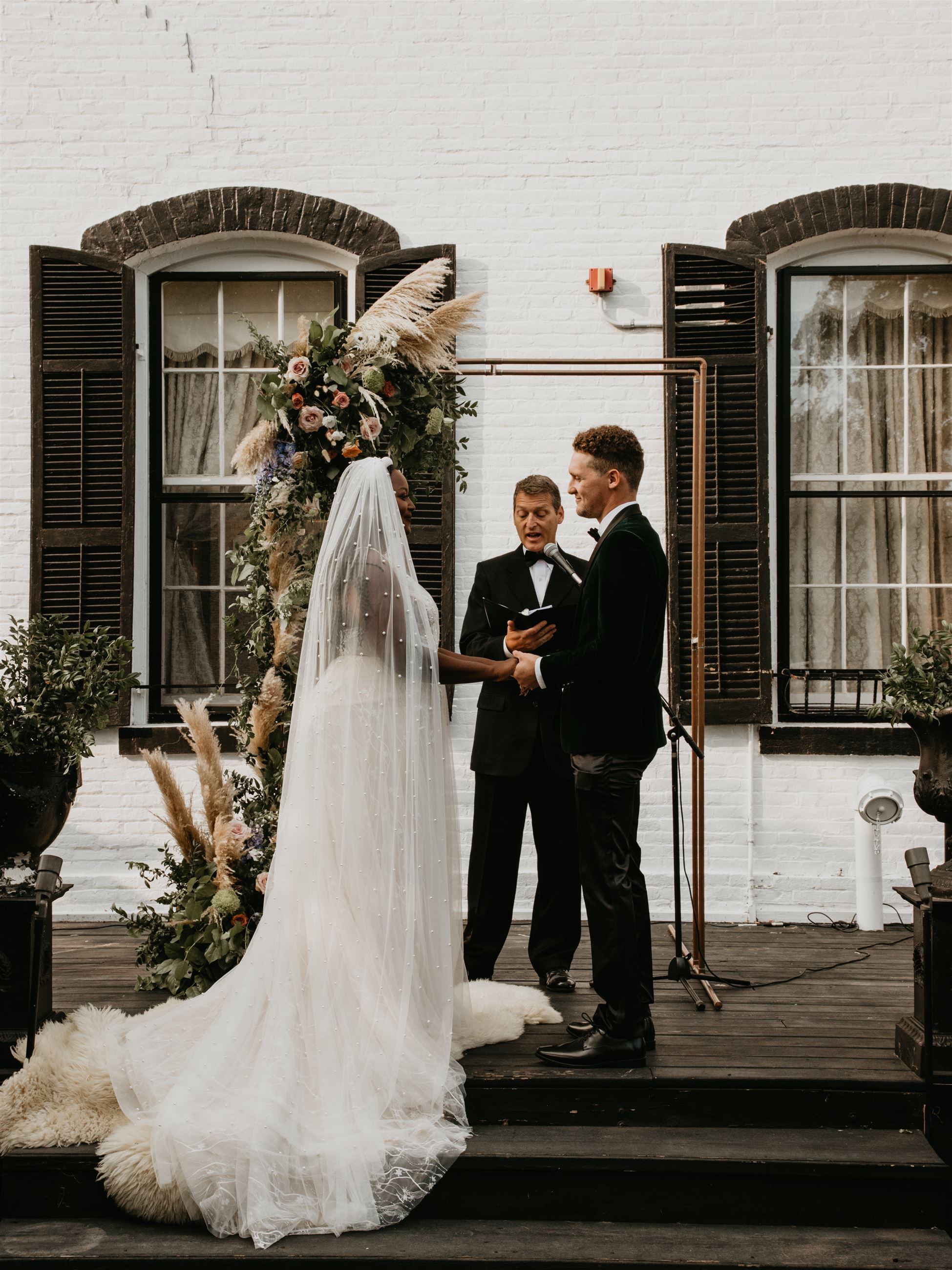 Bride and groom holding hands at the altar