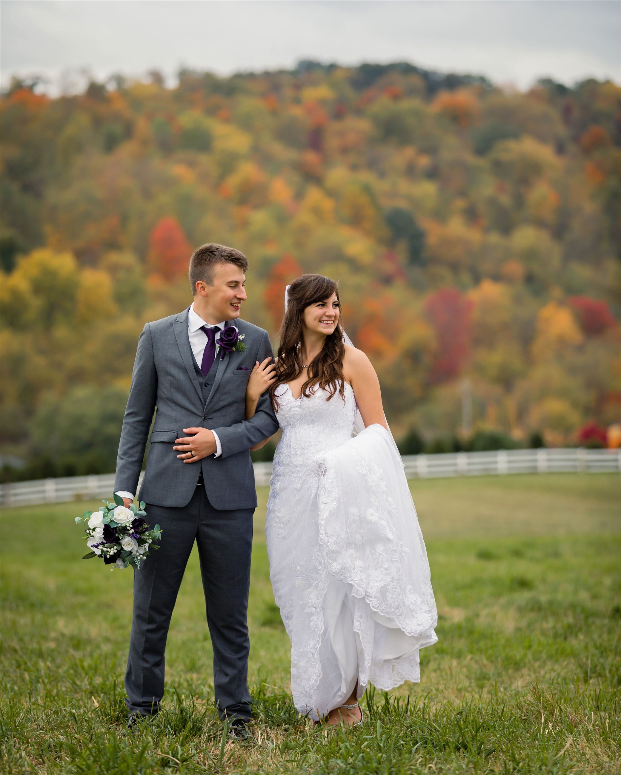 Bride and groom standing in a field 