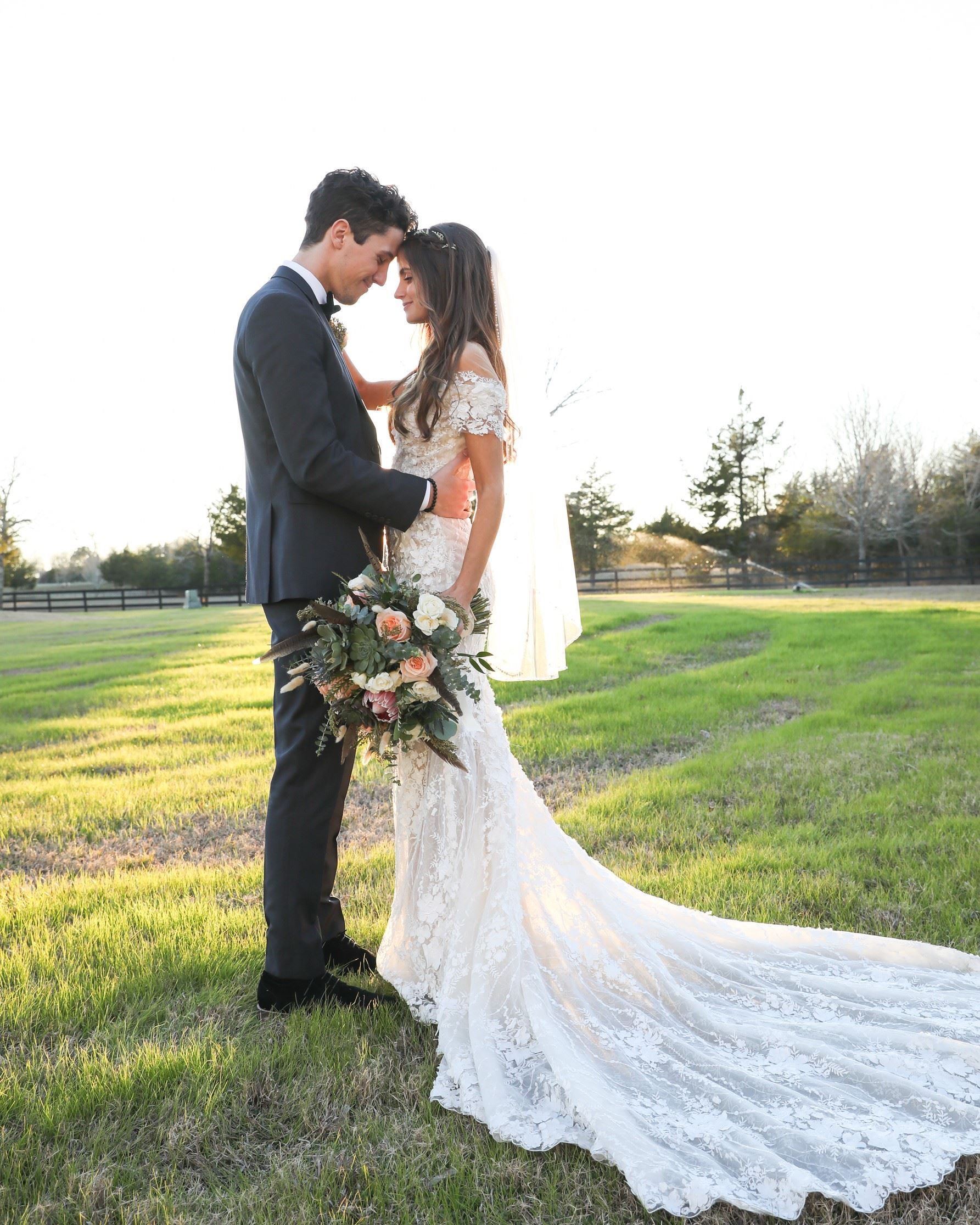 Bride and groom standing in field after they got married