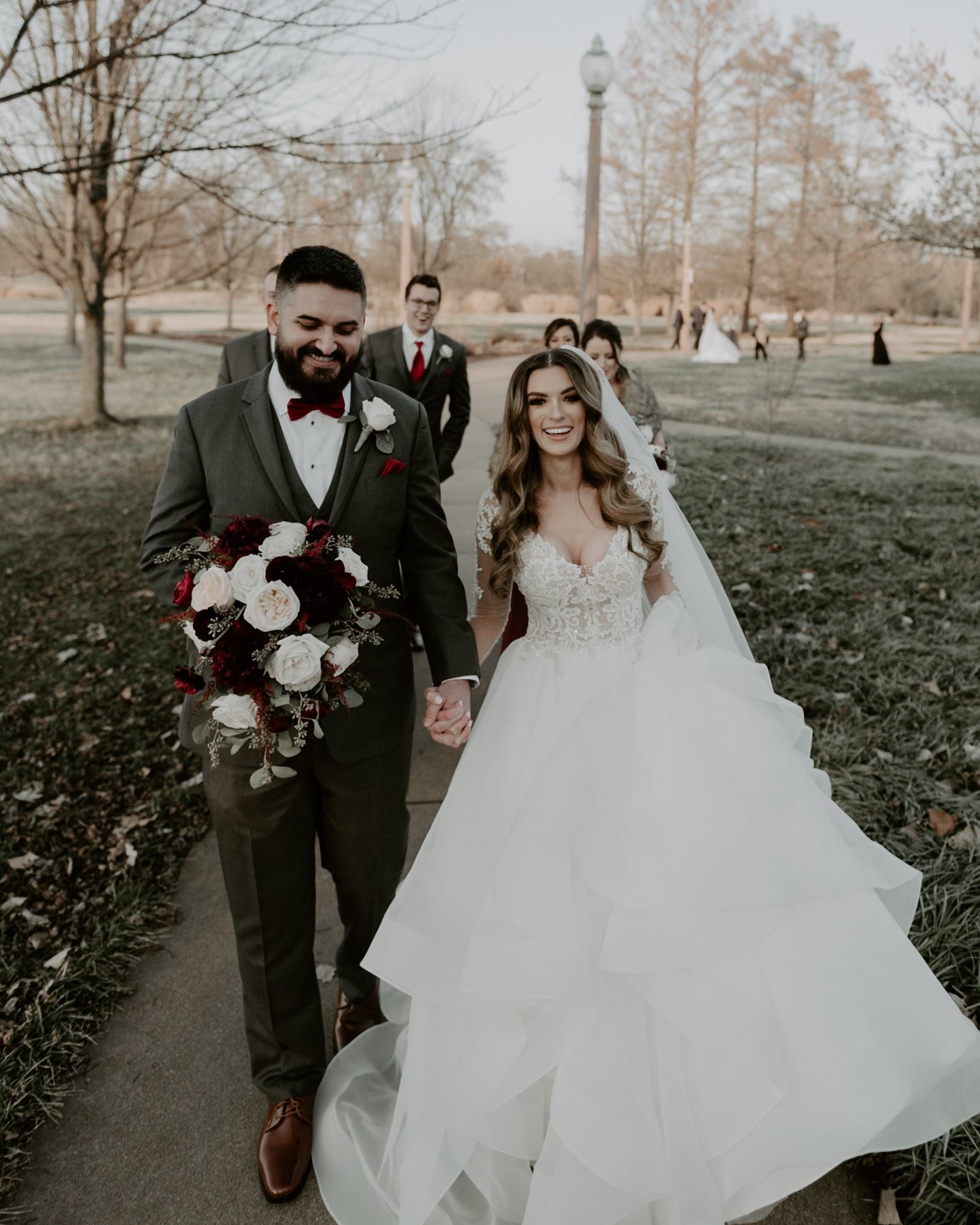 Bride and groom holding hands in front of their wedding party