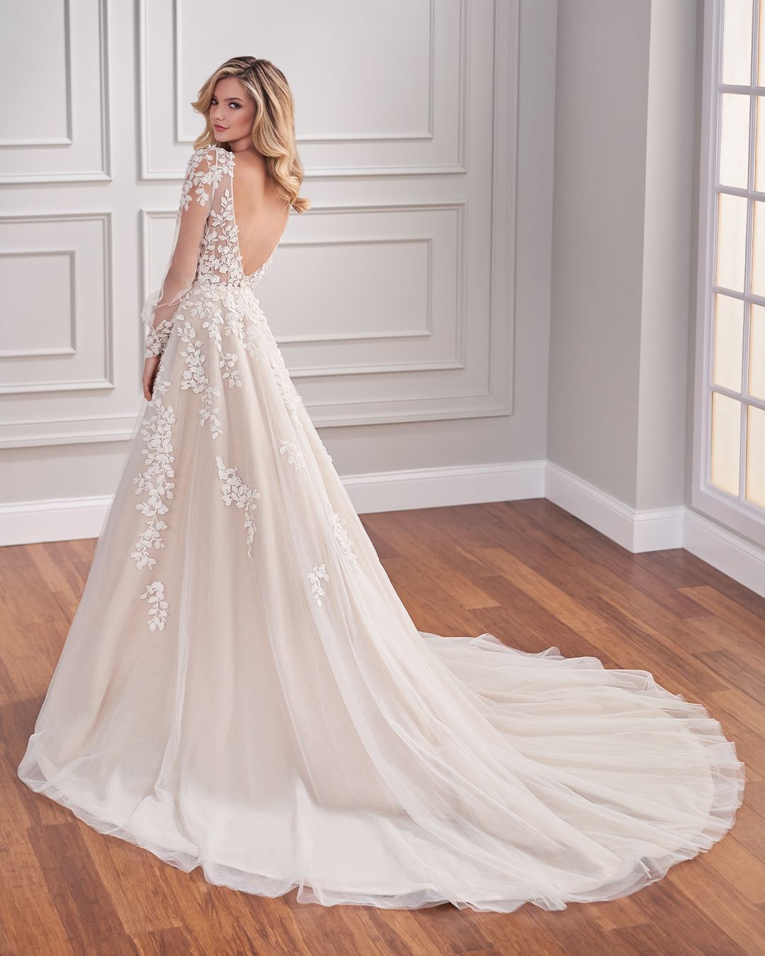 Bride wearing long sleeve wedding dress with open back