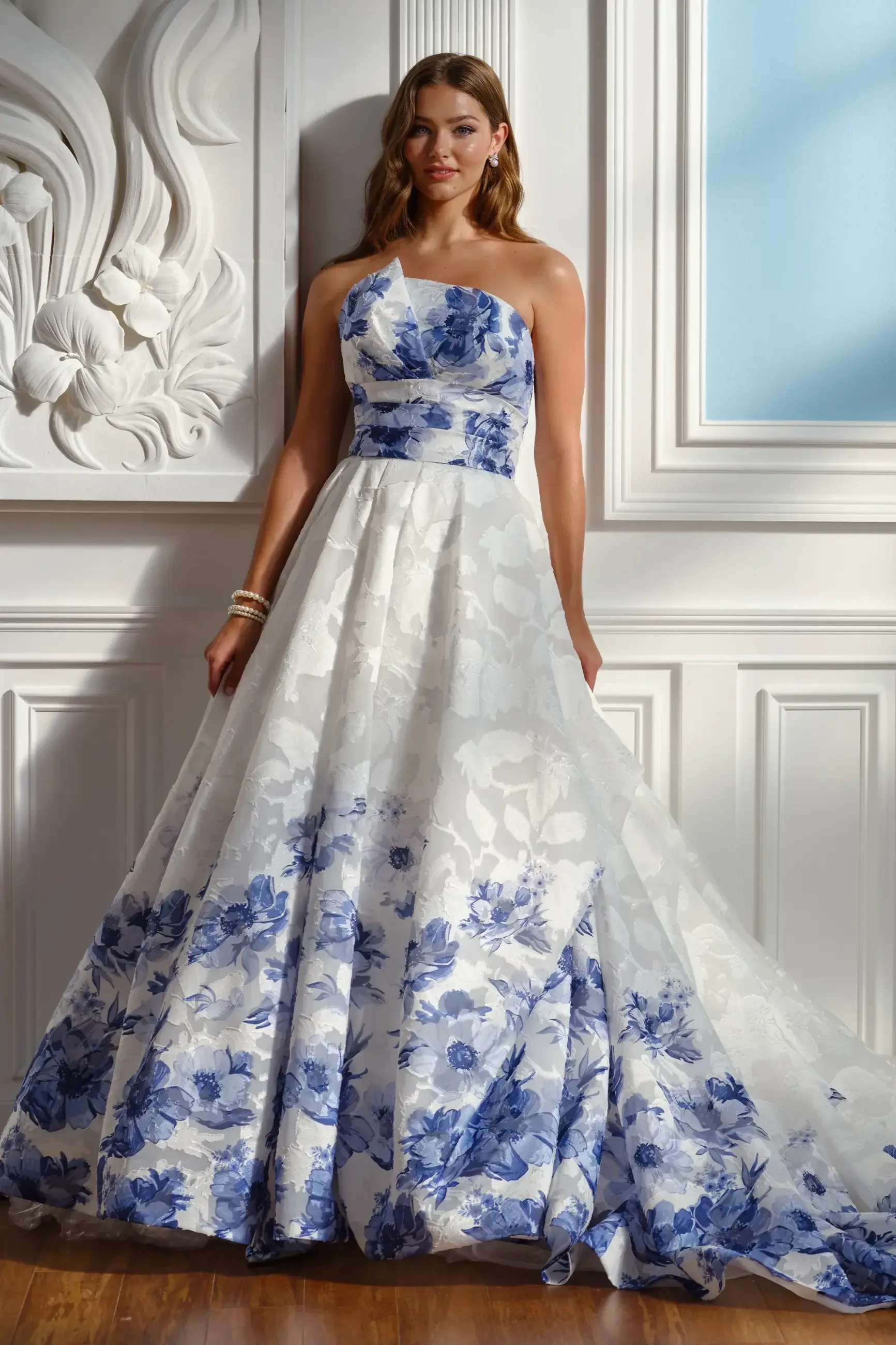 model is wearing a strapless a-line bridal gown with blue floral patterns