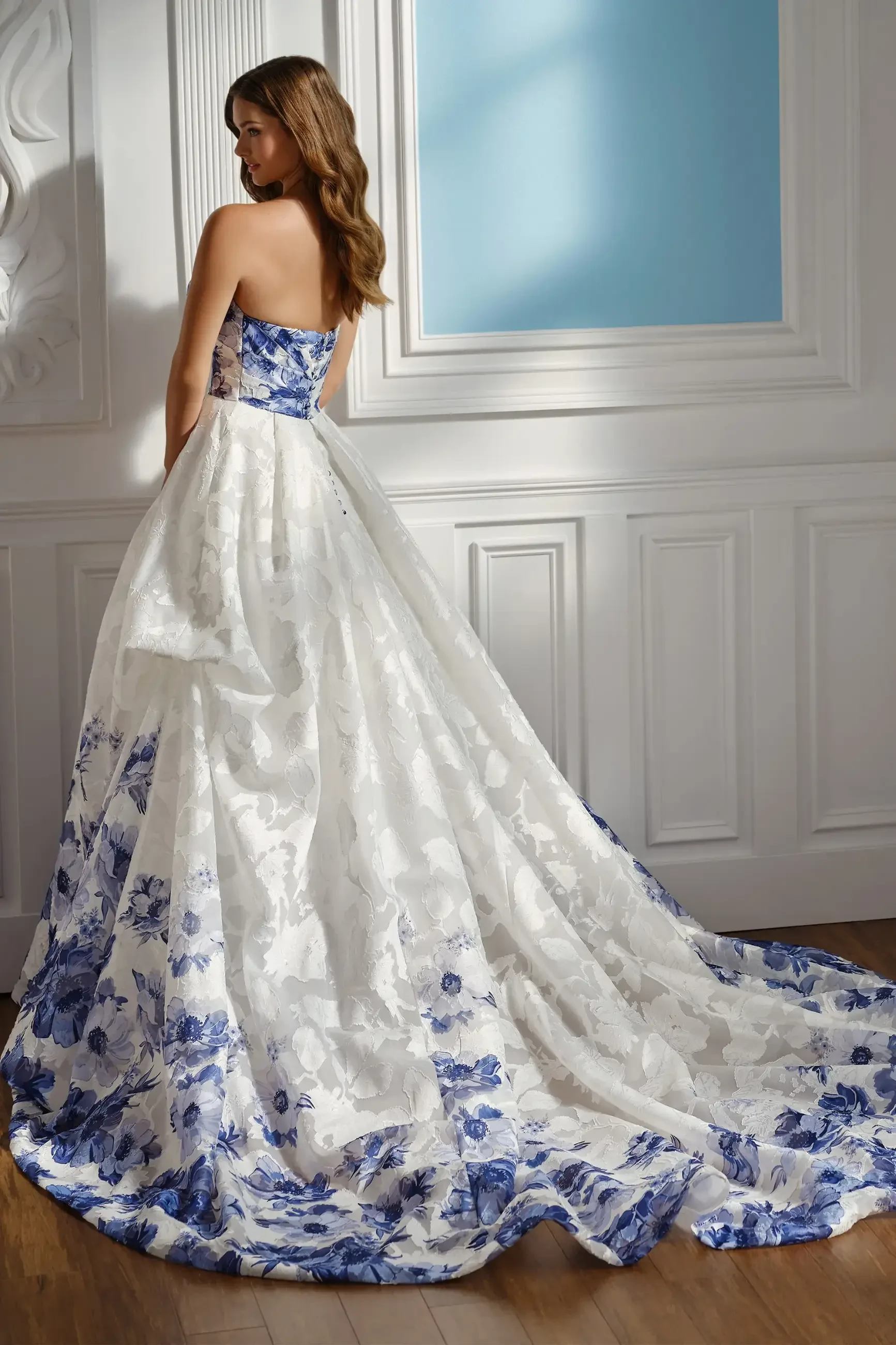 model is wearing a strapless a-line bridal gown with blue floral patterns