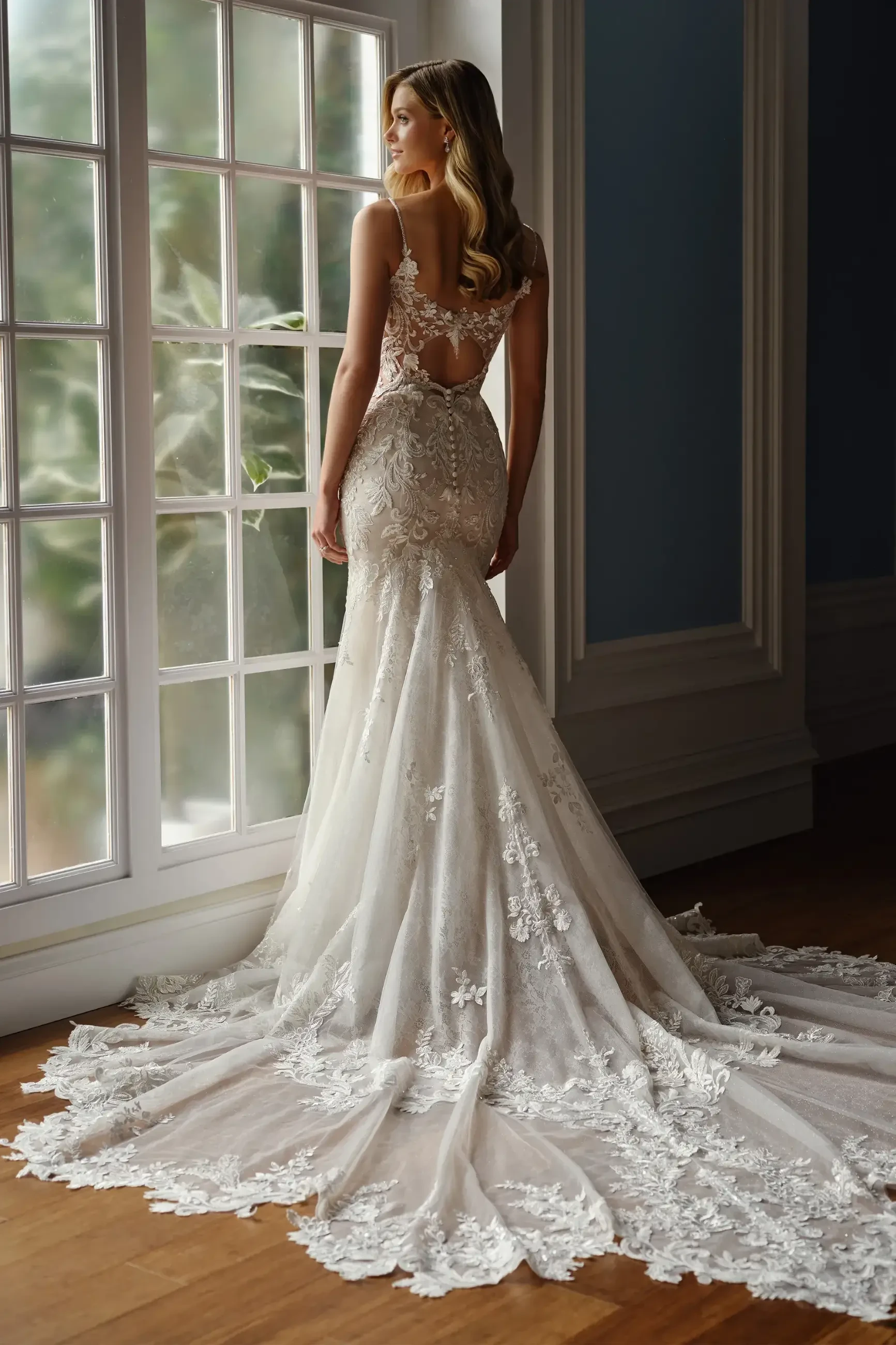 model is wearing a sleeveless fit and flare lace bridal gown