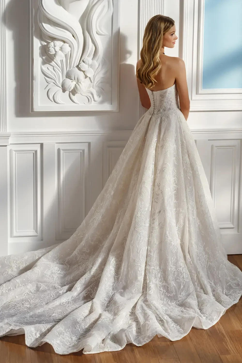 model is wearing a ball gown wedding dress with a slit