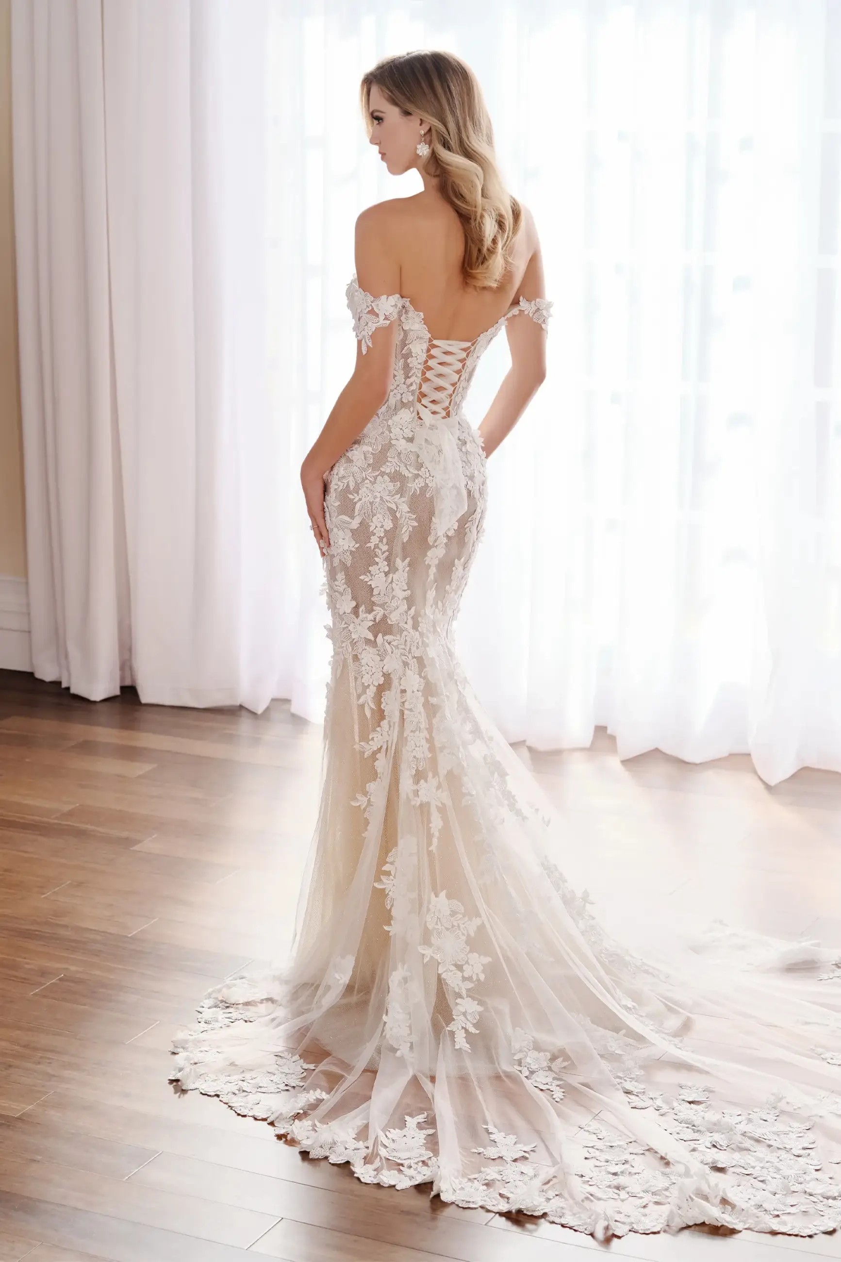 Model is wearing a floral lace mermaid wedding dress with 3D appliques