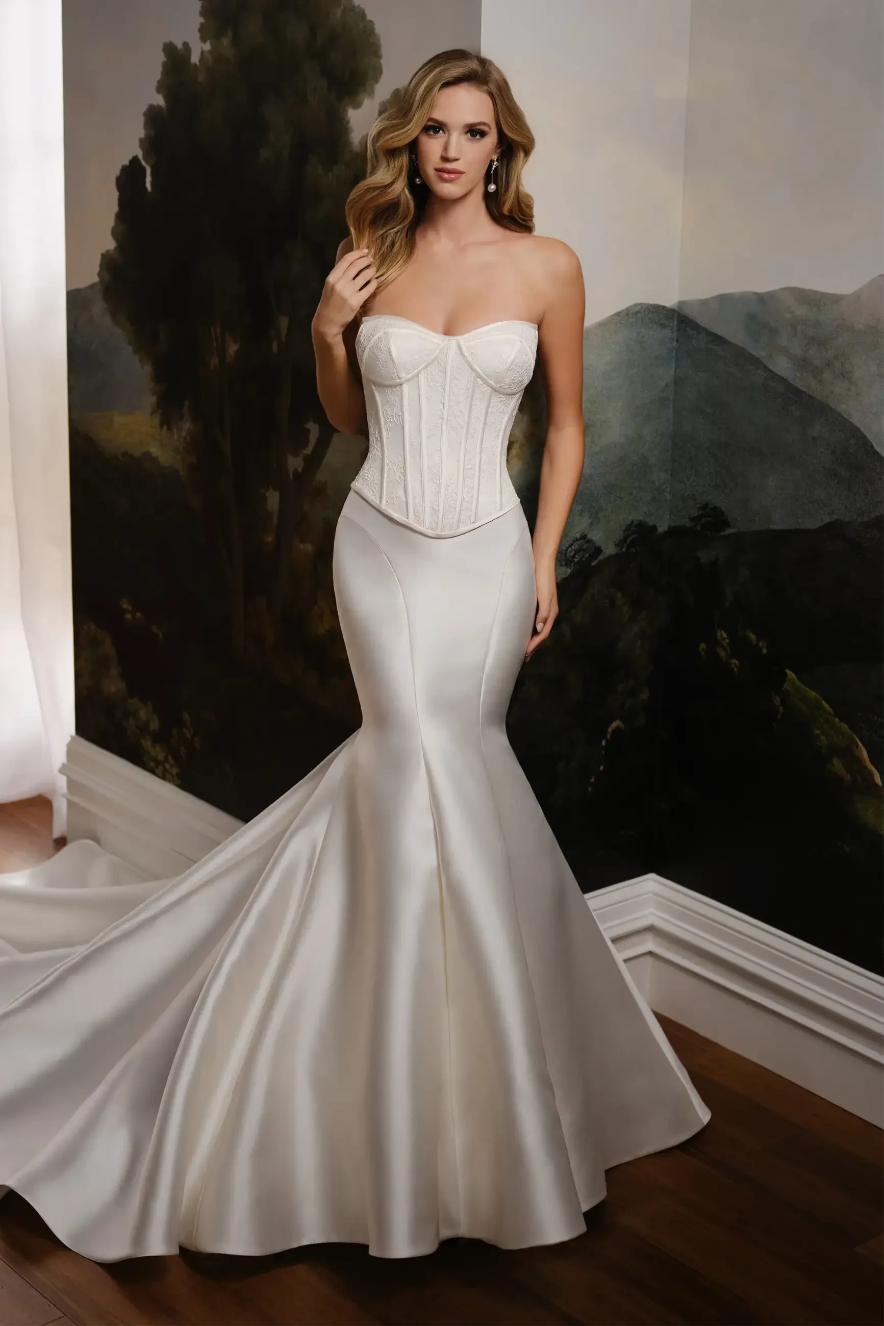 Model is wearing a trumpet gown with an allover lace bodice, sleek Mikado skirt, and back modesty panel.