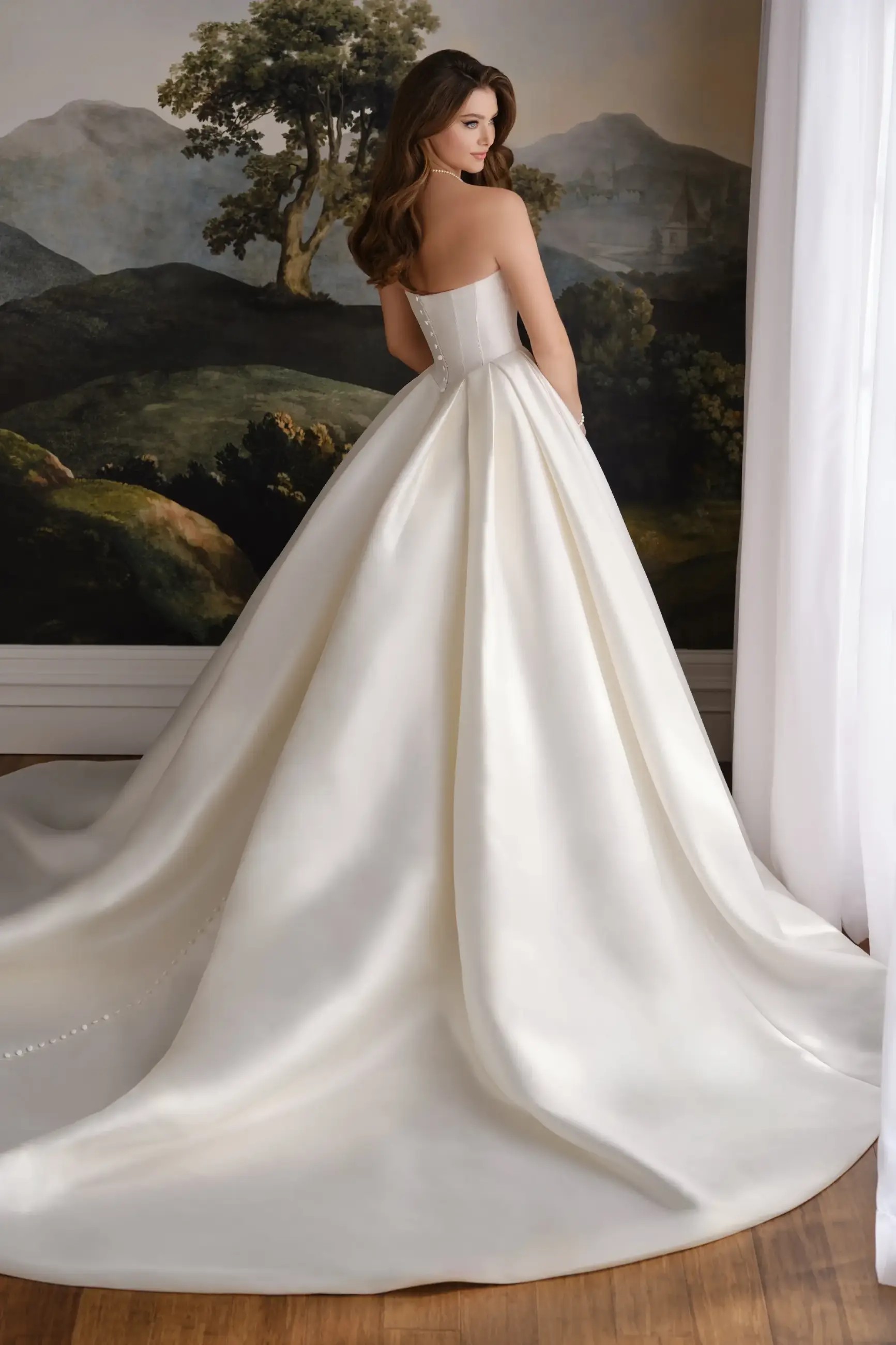 Model is wearing a mikado ball gown wedding dress with a sculpted neckline