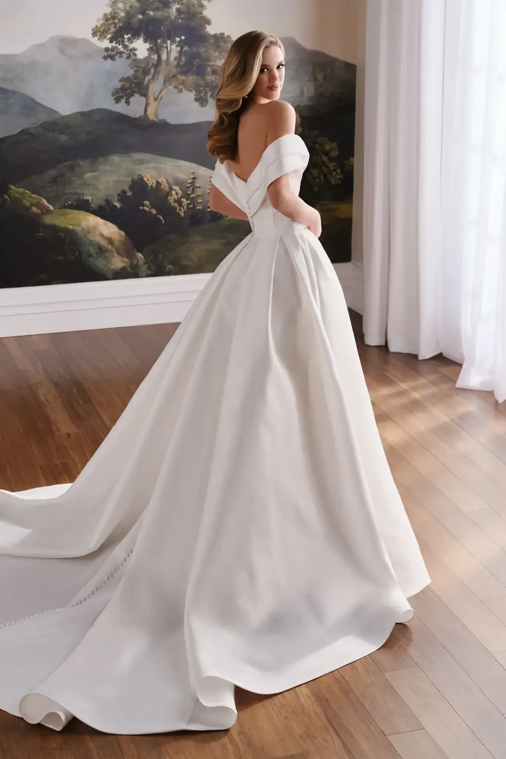 model is wearing a mikado off the shoulder bridal gown