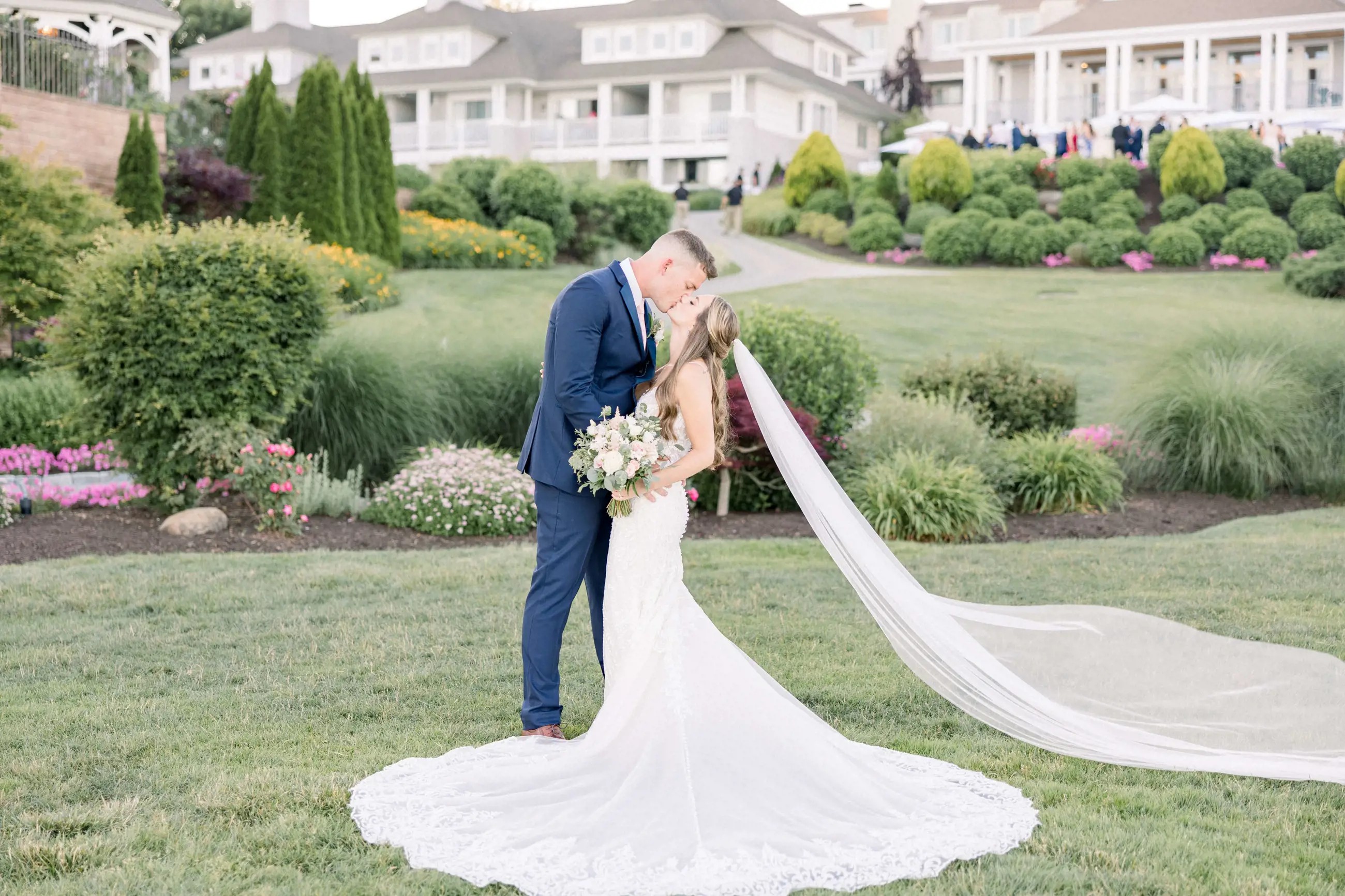 Сouple wearing a white gown and a blue suit on the grass