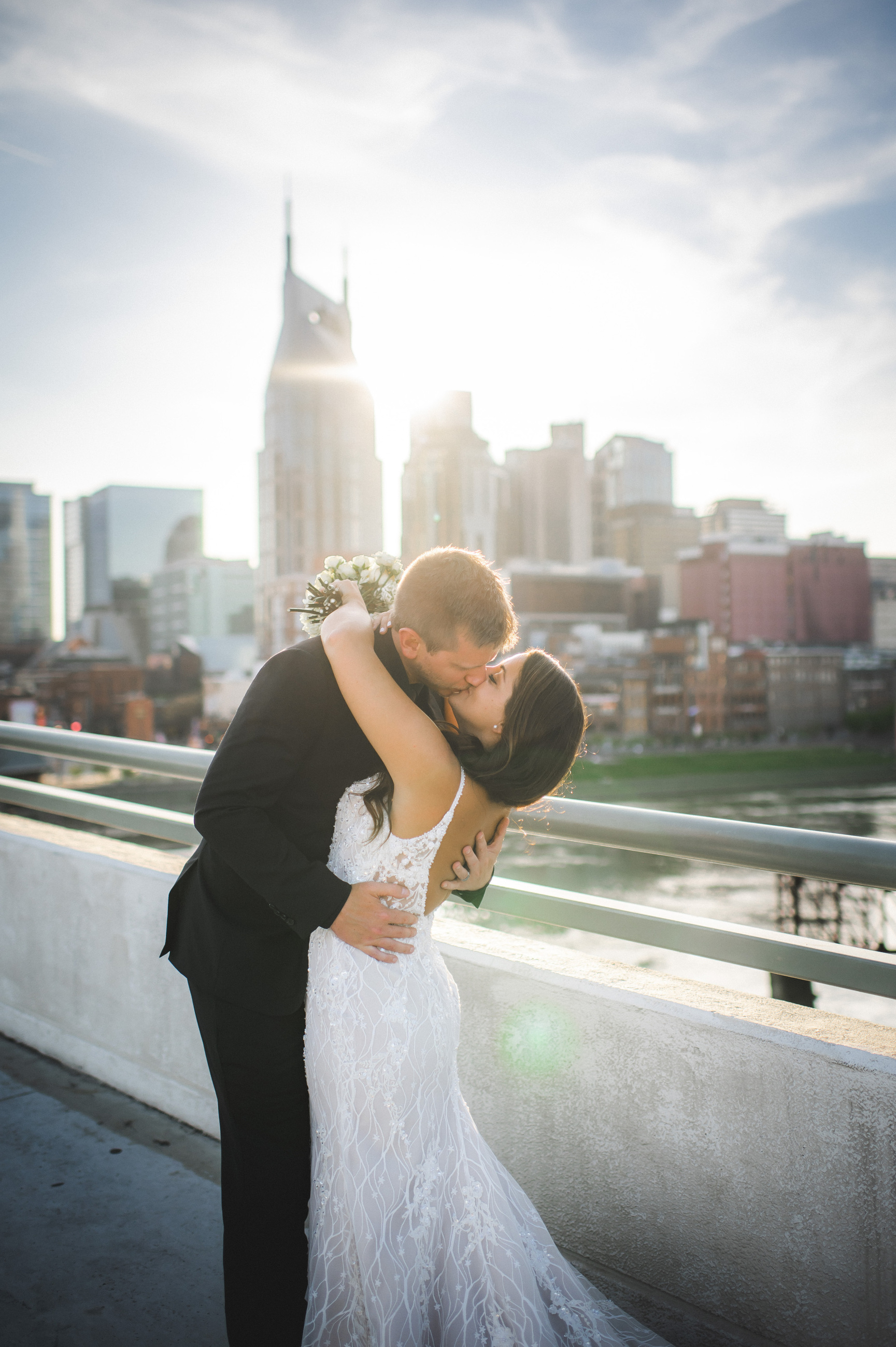 bride and groom kissing with skyline