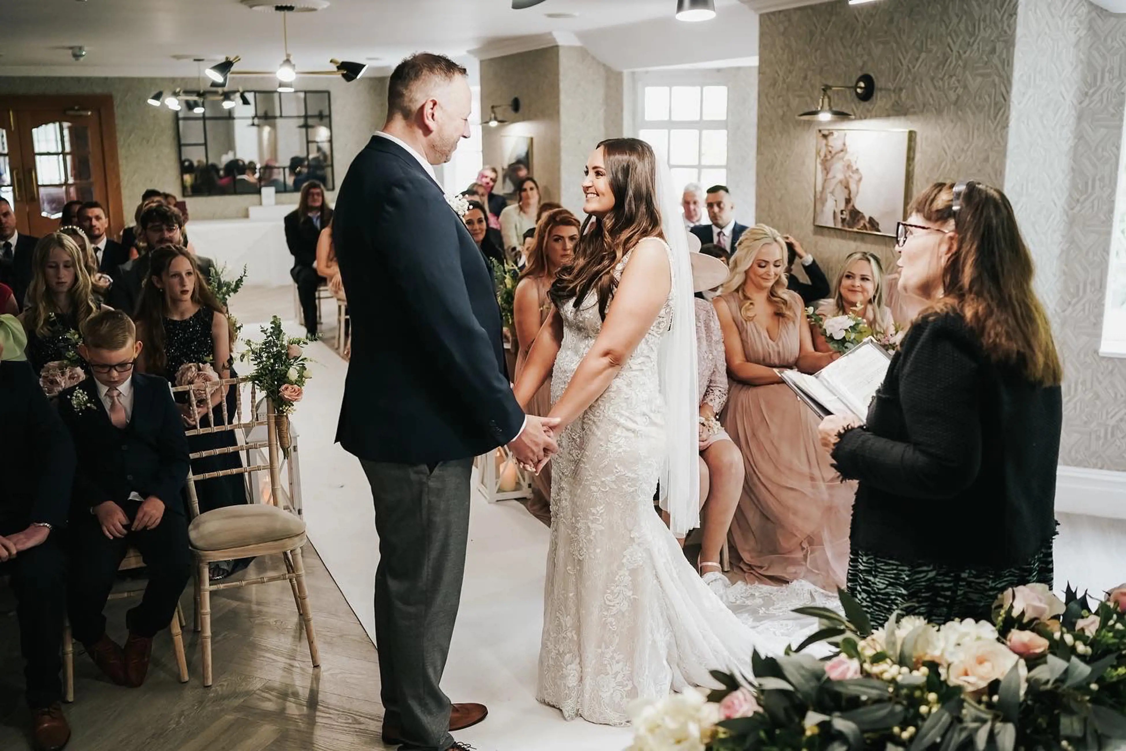 Сouple wearing a white gown and a black suit in the ceremonial hall