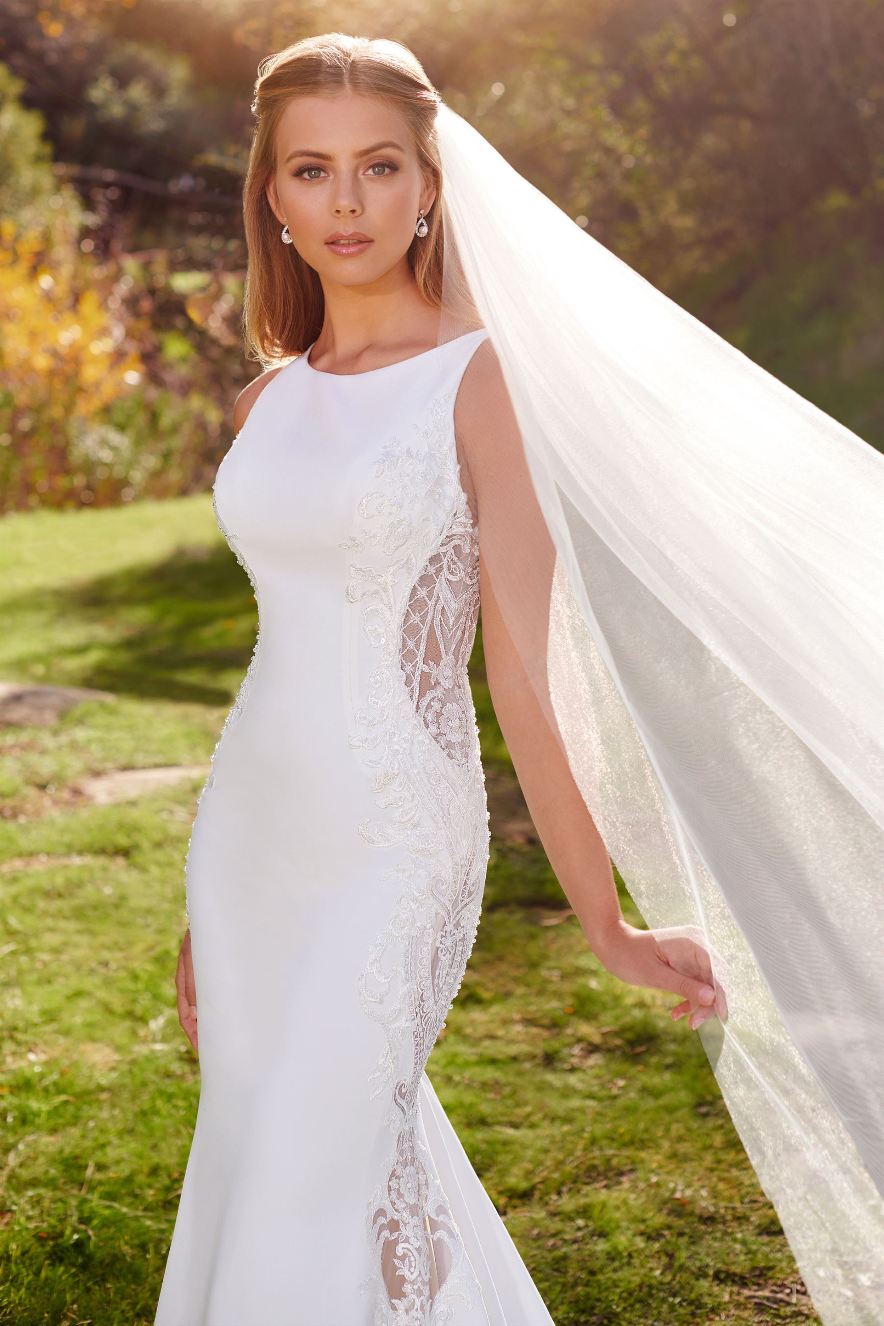 Blonde bride wearing veil and high neck wedding dress