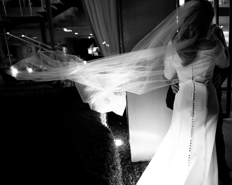 Black and white photo of a couple holding each other on their wedding day