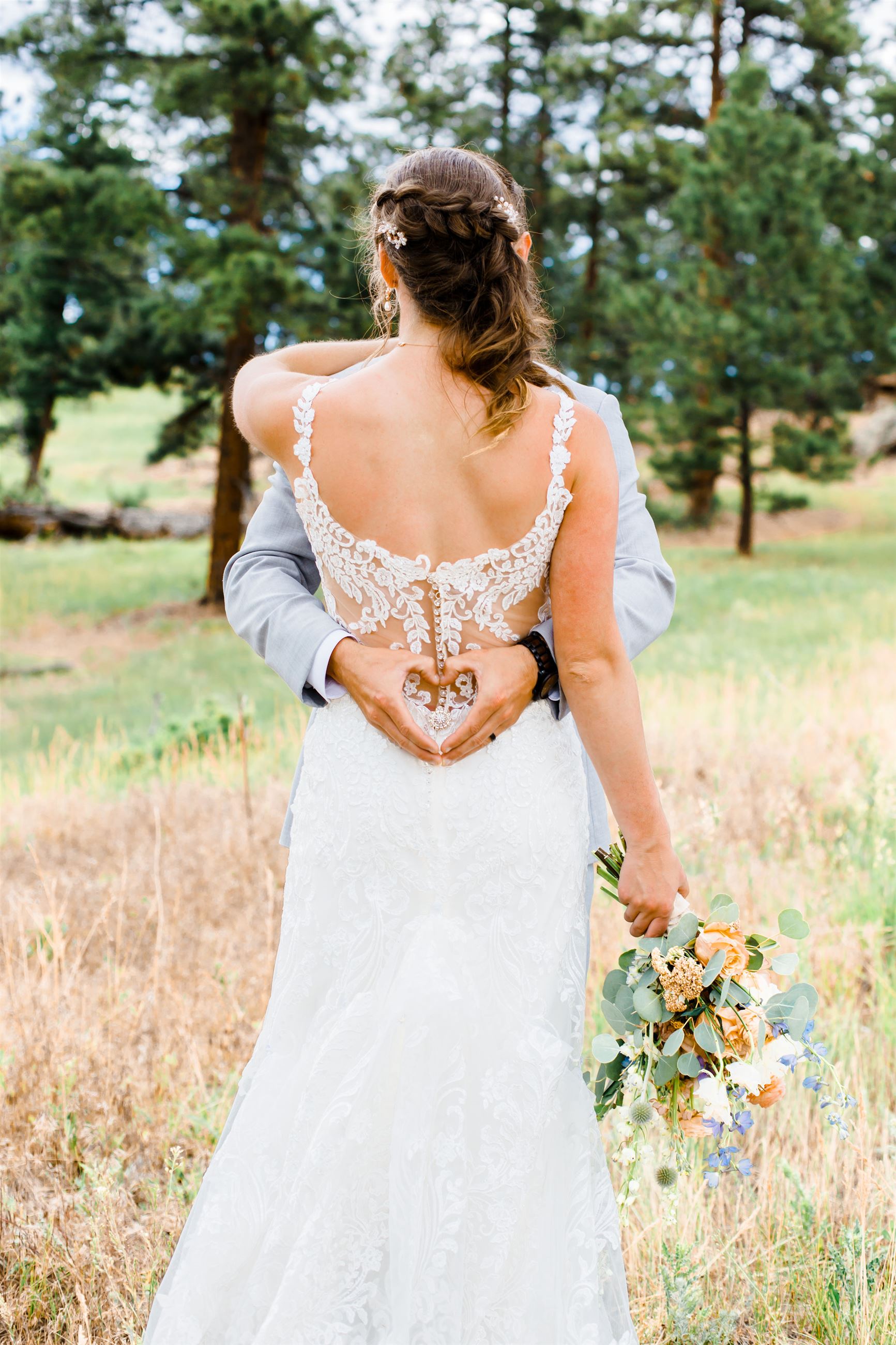 Bride and groom holding each other in a field on their wedding day