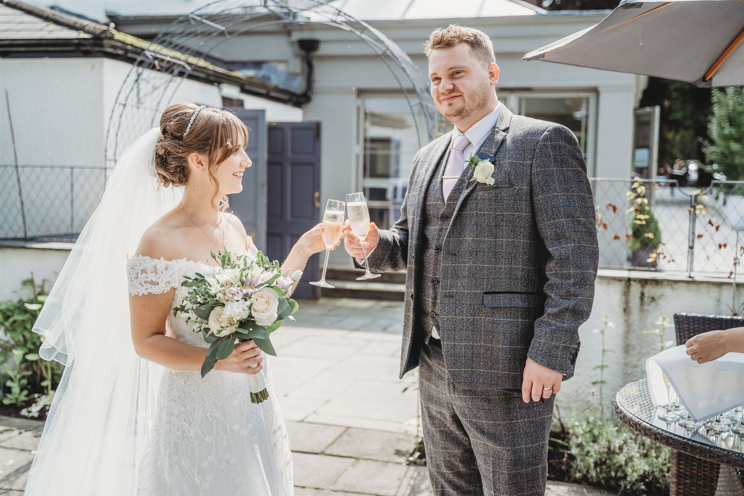 Bride and groom clinking glasses on their wedding day