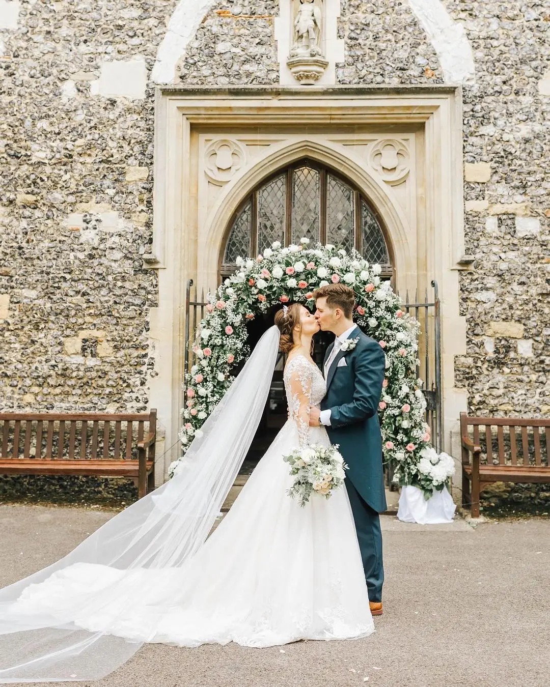 bride and groom kissing with flowers