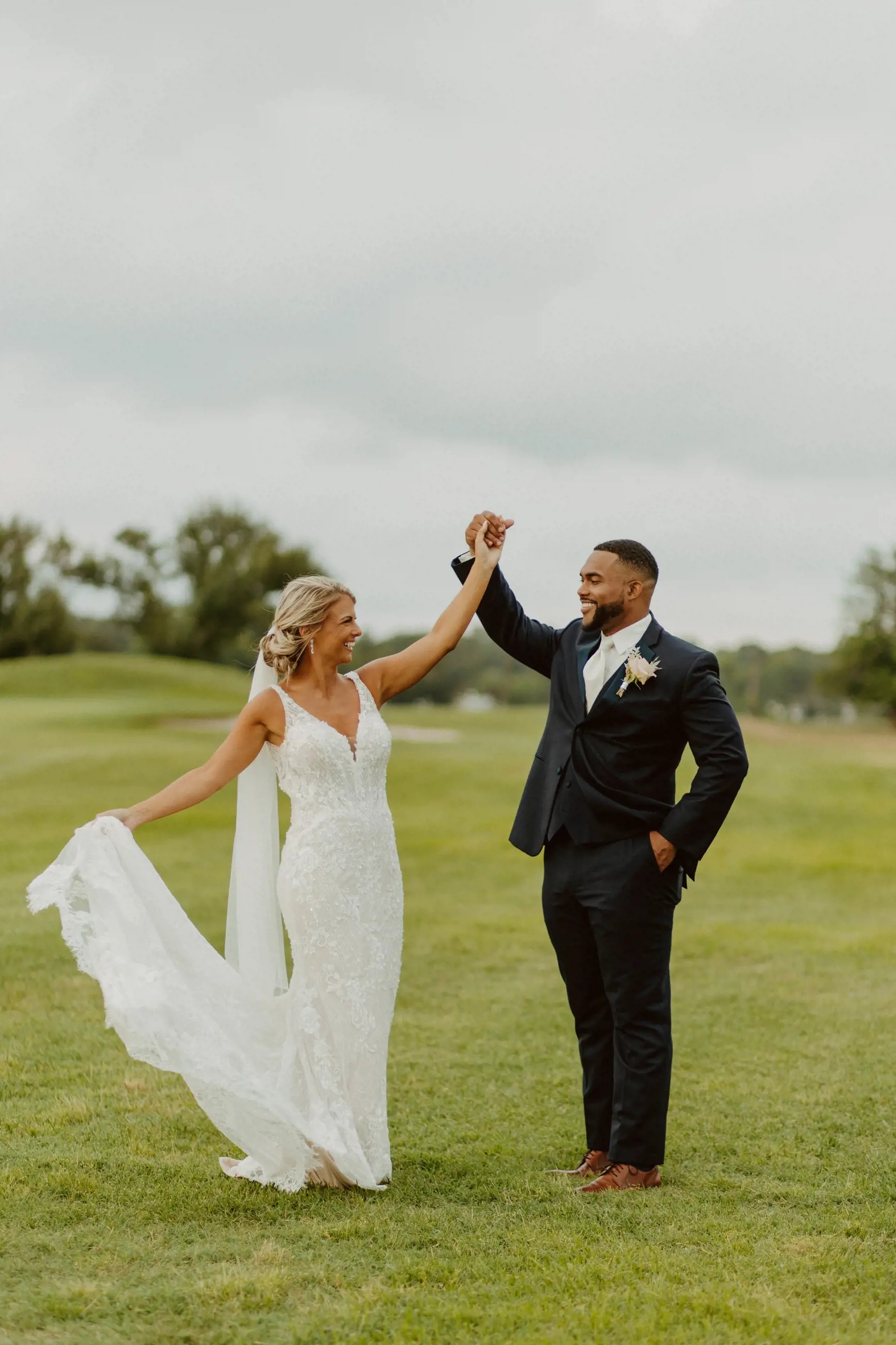 Сouple wearing a white gown and a black suit on the grass